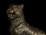 a bronze statue of a bear on a black background