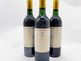 trois bouteilles de vin posées sur une surface blanche