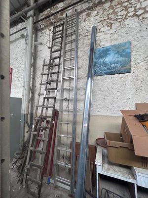 a ladder leaning against a wall next to a pile of boxes