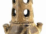 a gold vase with holes in it on a white background