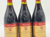 trois bouteilles de vin sont alignées sur une surface blanche