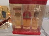 three bottles of perfume in a clear box on a table