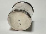 silver plated salt shaker on a white surface with a black handle