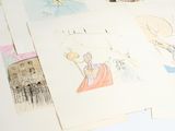 a pile of drawings on a table with scissors