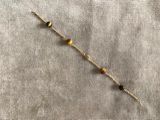 un gros plan d'un bracelet orné de perles, posé sur un tissu