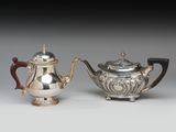deux théières en argent et une théière en argent posées sur une table