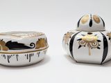 deux bocaux blancs et noirs ornés de motifs dorés