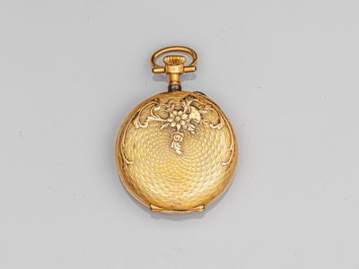 a close up of a gold pocket watch on a white surface