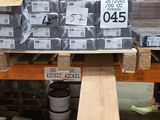 une grande quantité de bois d'œuvre empilée sur des palettes dans un entrepôt