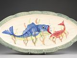 un plat en forme de poisson sur lequel sont disposés un poisson et un autre poisson