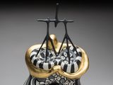 a black and white vase with a gold decoration on it