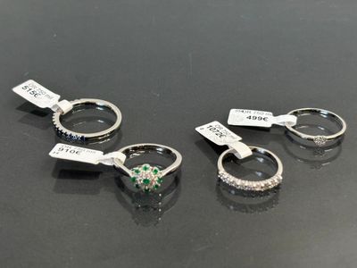 trois types différents de bagues, accompagnées d'étiquettes, posées sur une table