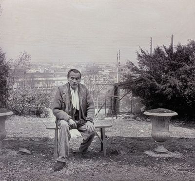 photographie en noir et blanc d'un homme assis sur un banc dans un parc