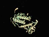 a close up of a chain on a black surface with a black background