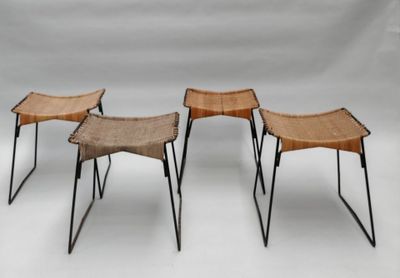 trois chaises aux pieds noirs et à l'assise en osier, sur fond blanc