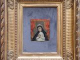 une image représentant un tableau d'une femme tenant un bébé dans ses bras, dans un cadre doré