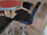 stools and a table in a small room with a red table top