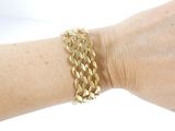 someone is wearing a gold bracelet with a chain on it
