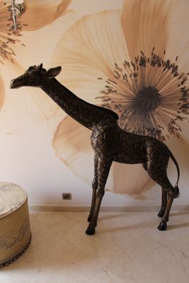 une girafe qui se tient devant une fresque murale