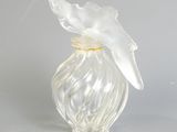 un vase en verre transparent surmonté d'un oiseau