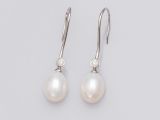 a pair of pearl and diamond earrings