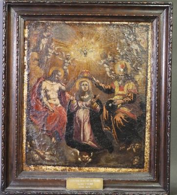 un vieux tableau représentant la Vierge à l'Enfant entourée d'anges, dans un cadre en bois
