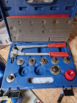 une boîte à outils bleue avec des outils sur le sol