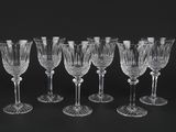 six crystal wine glasses on a black background