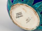 a close up of a blue vase with green leaves on it