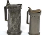 deux objets en pewter posés l'un à côté de l'autre sur une surface blanche