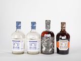 trois bouteilles d'alcool sont alignées sur une surface blanche