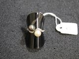 a ring with two pearls on it sitting on a table