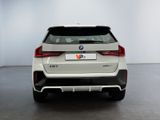 the rear end of a white bmw suv parked in a garage