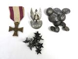 Plusieurs médailles et insignes militaires sont disposés sur une surface blanche