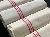 six serviettes rayées de blanc et de rouge empilées les unes sur les autres
