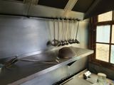 a kitchen with a stove, sink, and pots and pans on the counter