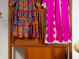 deux robes suspendues à un portant dans une pièce