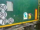 a green truck with stickers on the side of it