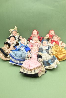 a group of dolls that are sitting on a green surface