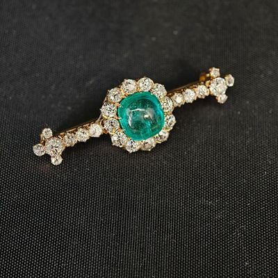 un gros plan sur une broche en forme de losange verte et blanche