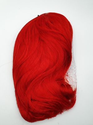 a close up of a red wig on a white surface