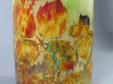 a glass vase with a painting of leaves on it