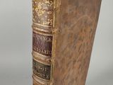 an old book sitting on top of a table next to a white wall