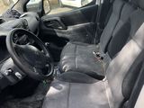 the interior of a car with the door open and the driver ' s seat down