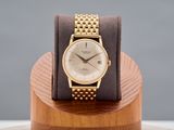 une montre-bracelet en or posée sur un socle en bois