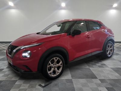 a red nissan suv parked in a room with a checkered floor