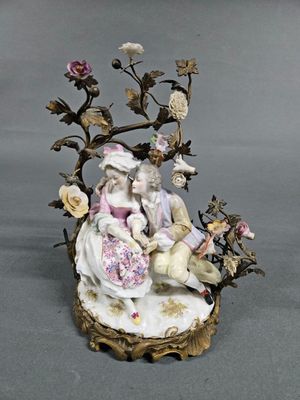 a figurine of a man and a woman sitting on a tree