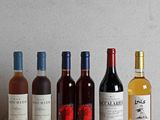 plusieurs bouteilles de vin sont alignées sur une table en bois