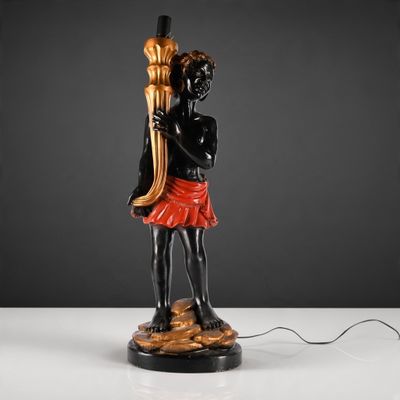 a black and gold statue of a woman holding a torch