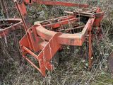 un vieux tracteur rouillé et une charrue au milieu des mauvaises herbes
